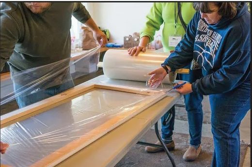 Volunteers building a window insert